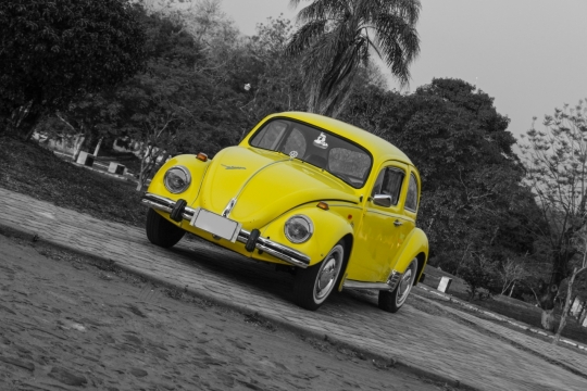 黑白背景下停在路上的黄色大众甲壳虫汽车