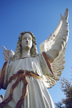 公园中高大天使石雕阳光照射外景