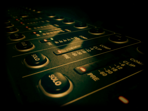 音控设备众多按钮微弱灯光下特写