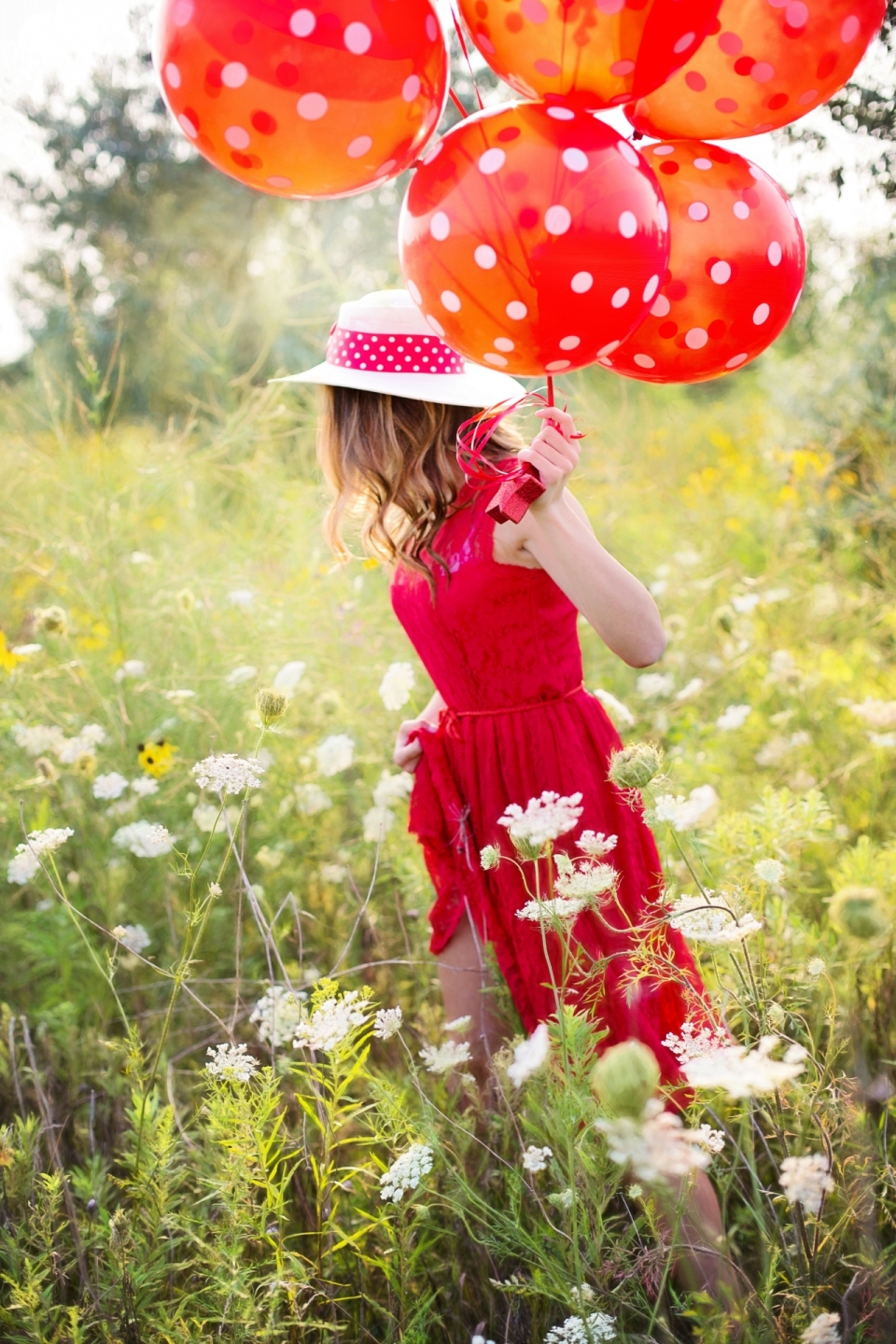 在花草丛中穿着红衣拿着红气球的欧美美女
