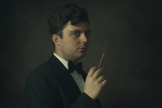 人物摄影_黑色背景穿西装拿雪茄男性肖像写真