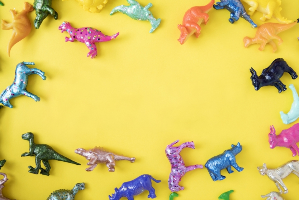 黄色背景彩色恐龙塑料童趣玩具装饰