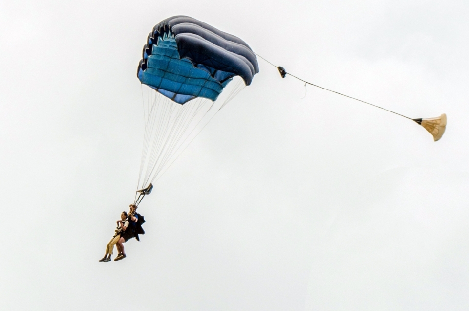 白色背景前一对男女在空中一起跳伞摄影