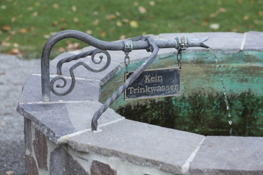 公园草坪前石质复古水井