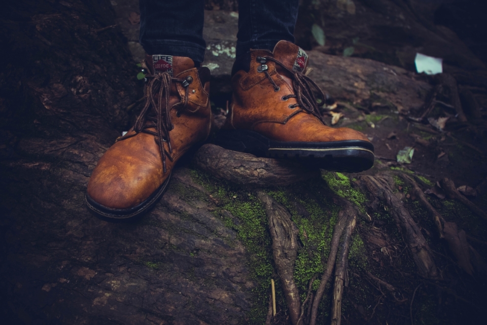 自然森林树木上站立穿工装鞋男性