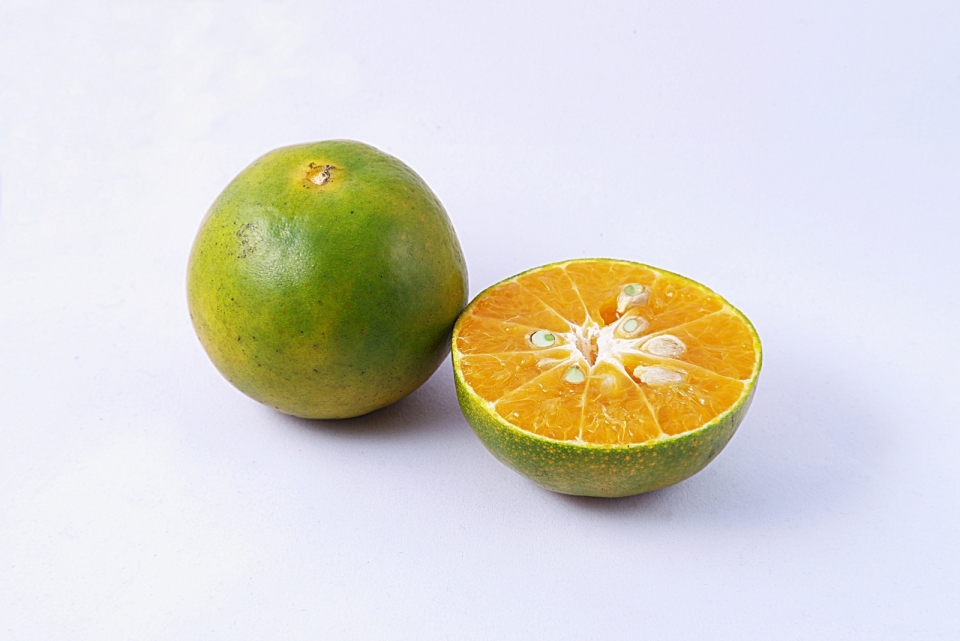 白色背景绿色橘子被切开橙色果肉