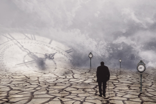 时钟背景下走在干裂道路上的老人