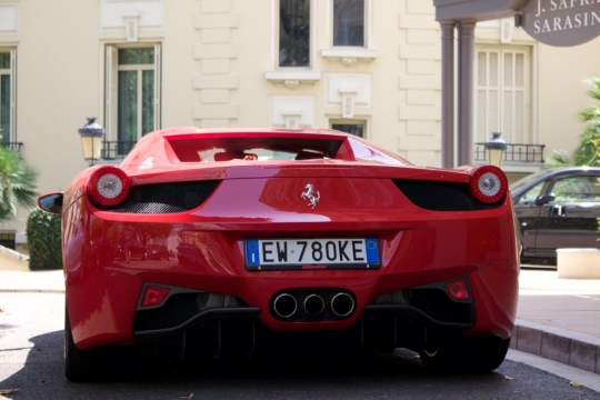 阳光城市街道建筑边崭新豪华红色跑车