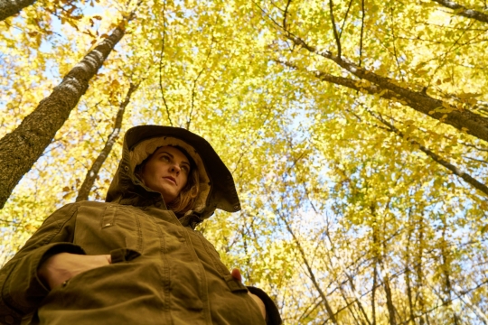 金黄色森林下站立着的女性特写
