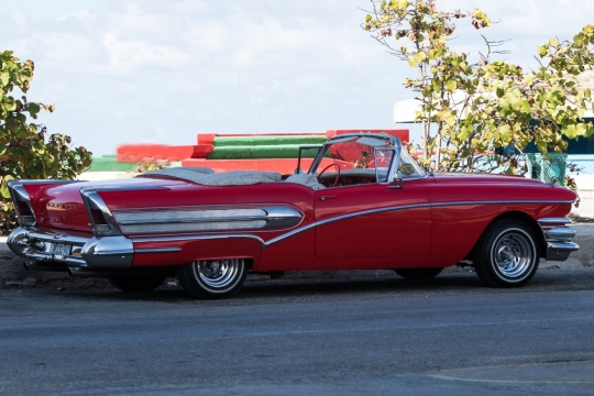 路边阴影中敞篷红色跑车特写