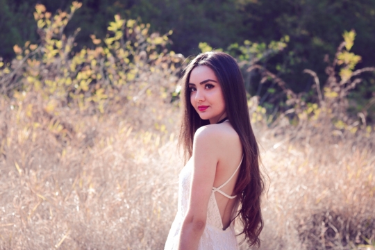 户外草丛中穿着白色露背装的美女写真摄影