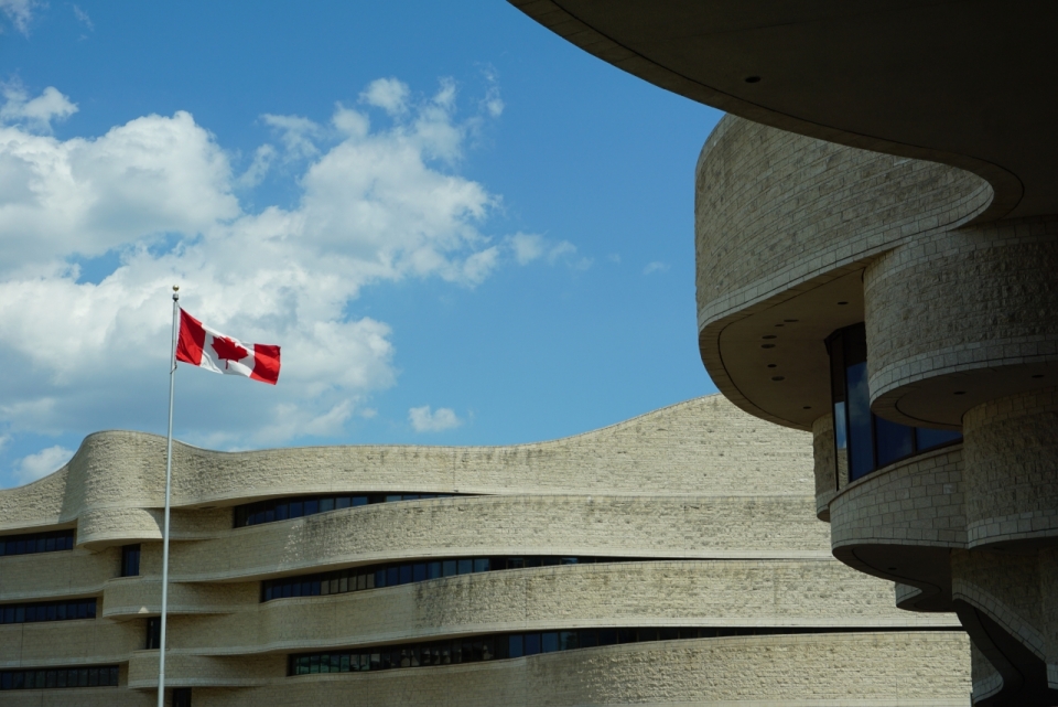 蓝色天空古老建筑间红色白色加拿大国旗