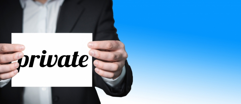 蓝色背景西装男性拿白色英文卡片