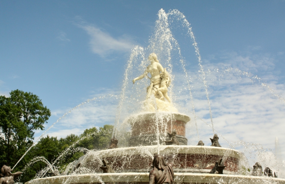 蓝色天空下城市街道金色雕塑石质喷泉