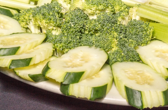 黑色桌面白色盘子新鲜黄瓜西兰花蔬菜