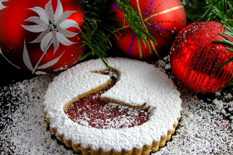 桌子上洒满糖粉的天鹅饼干和圣诞树装饰瓶