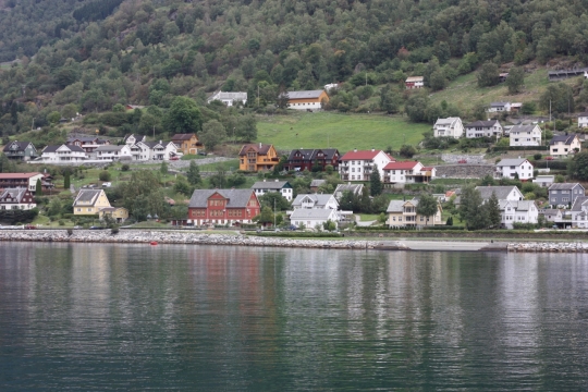 高山绿树湖泊旁的房屋建筑