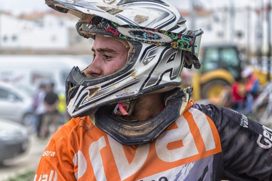 赛场旁带着头盔看着前方的赛车手