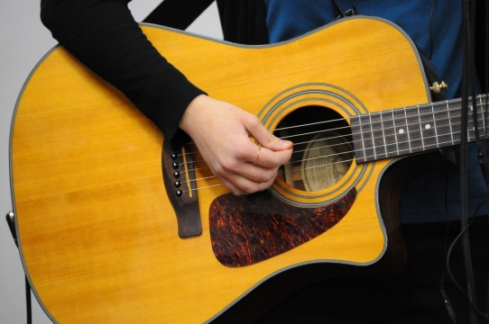 白色背景戴戒指音乐人弹奏吉他乐器