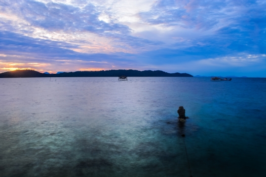 傍晚蔚蓝大海漂浮孤单船只阴影
