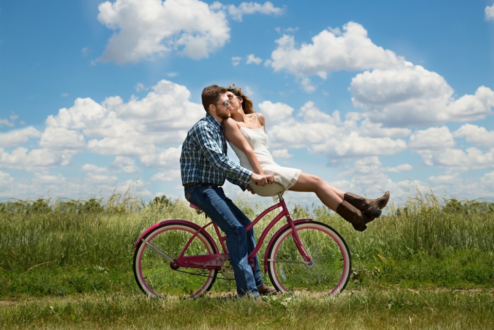 在草地上骑自行车情侣甜蜜秀恩爱