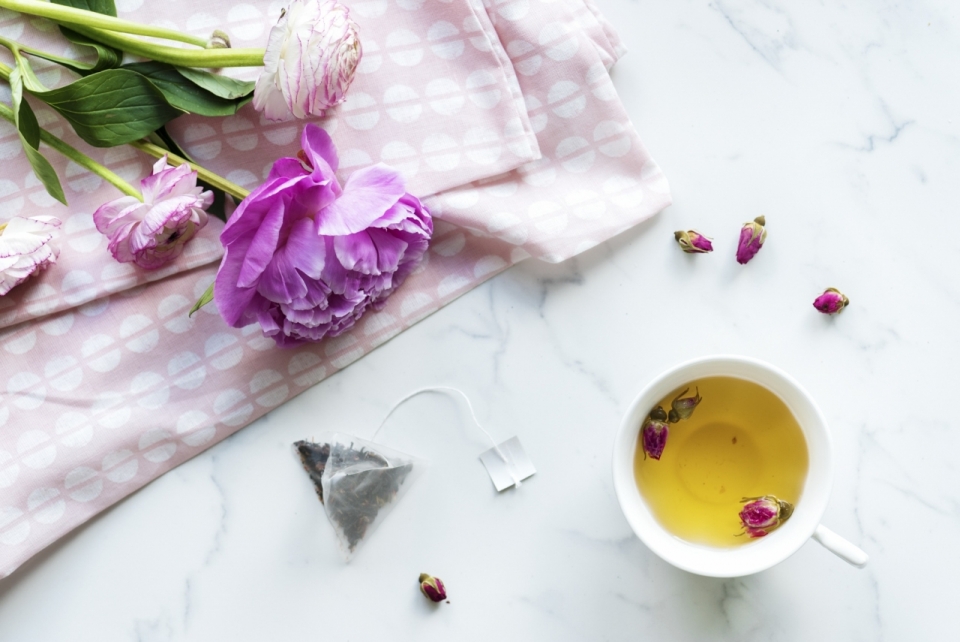 白色大理石桌面桌布白色杯子黄色茶饮花朵植物