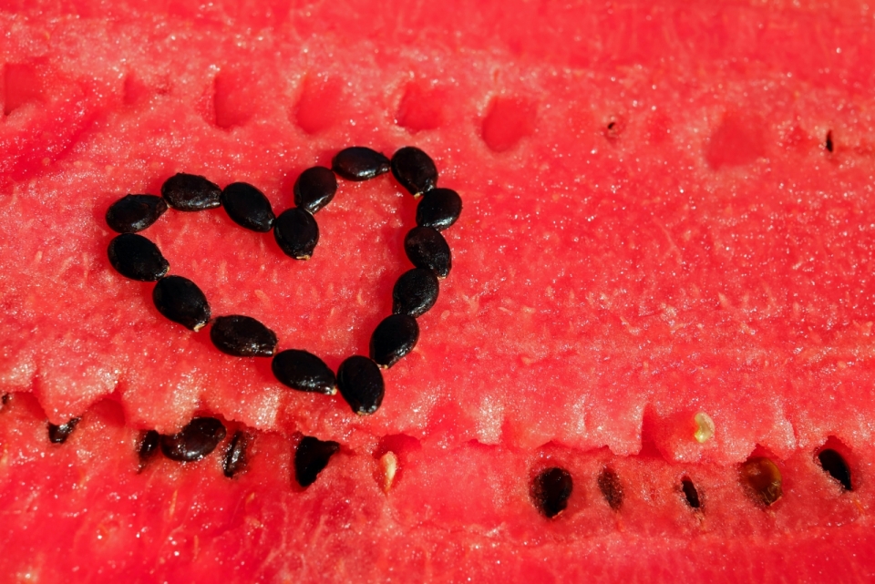 黑色西瓜子在西瓜上摆出了爱心的形状