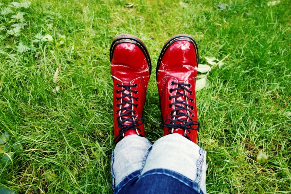 草地上红色鞋子的左脚放在右脚上面