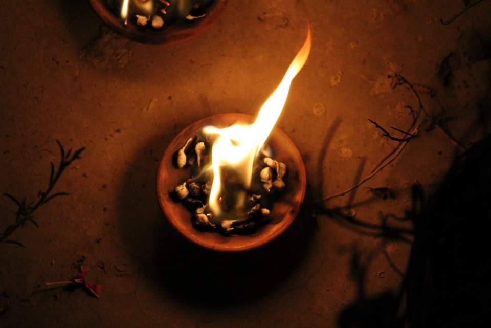 昏暗室外燃烧火焰发出光芒的暖色调蜡烛