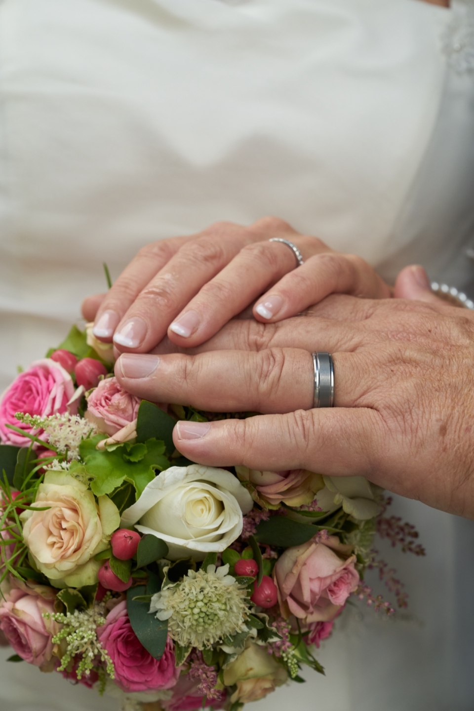 婚礼男性女性戴戒指双手放浪漫花束上