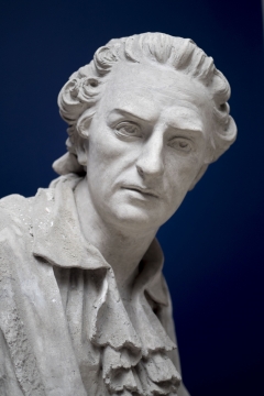 蓝色背景短发男性白色石质胸像雕塑