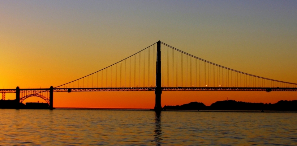 夕阳背景横跨江流的大桥建筑摄影