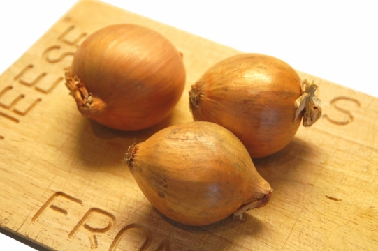 白色背景木制案板上新鲜健康洋葱蔬菜
