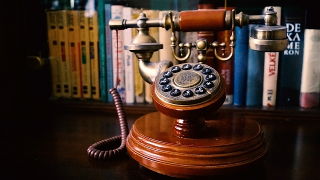 桌上排列的图书和摆放的复古电话机