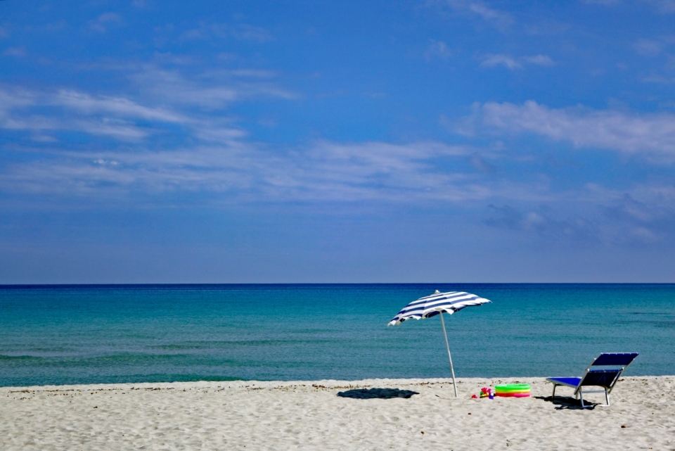 烈日炎炎海边沙滩遮阳伞躺椅外景