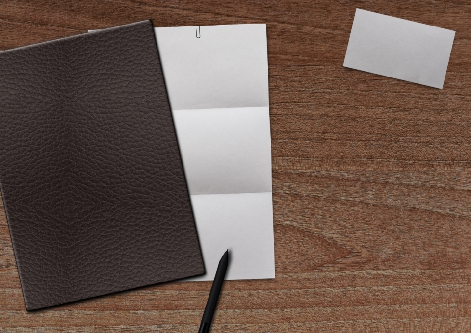 木制桌面白色纸卡片褐色封面笔记本笔