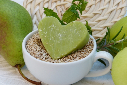 装满芝麻的茶杯上放着绿色抹茶心形甜点