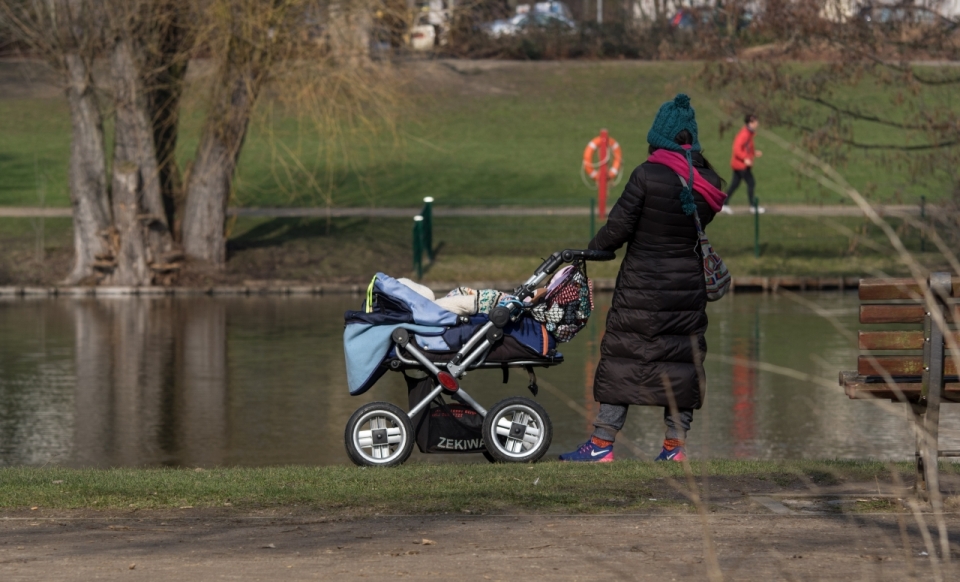 公园街边推婴儿车散步妇女背影