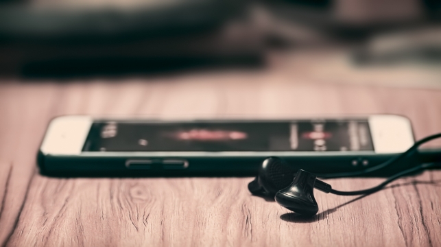 木质桌面上手机耳机静物摄影