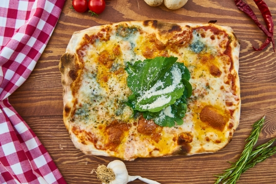 桌子上红白格子桌布和烤披萨美食