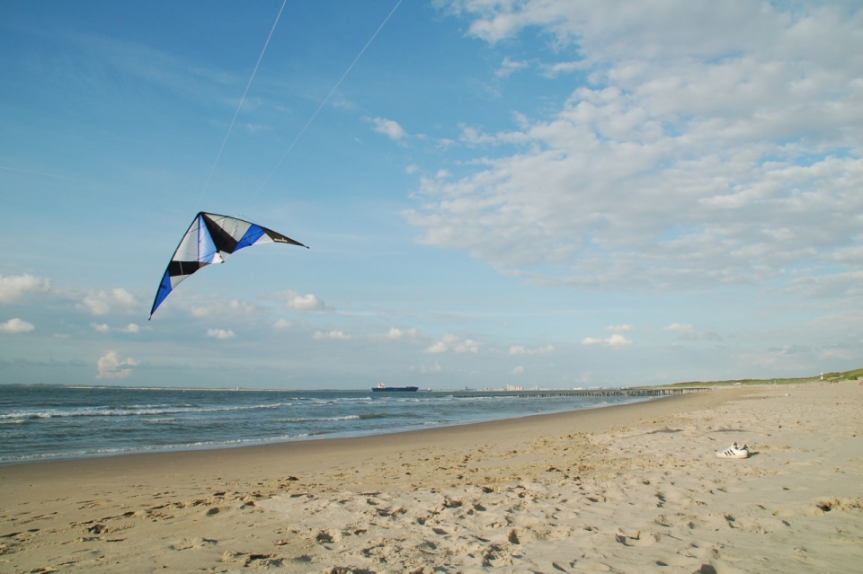 空旷沙滩旁放飞风筝游玩美景