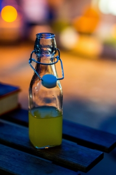 虚化灯光背景木制桌面玻璃瓶新鲜果汁