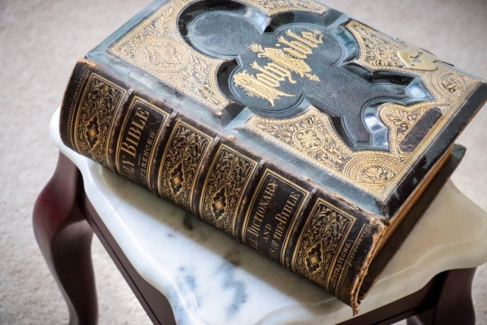 室内地板凳子上黑色古典封面书本