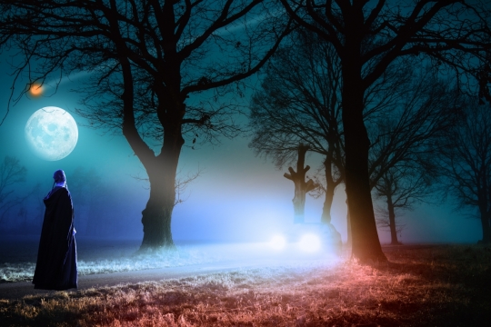 月夜马路中间穿着黑袍的男子