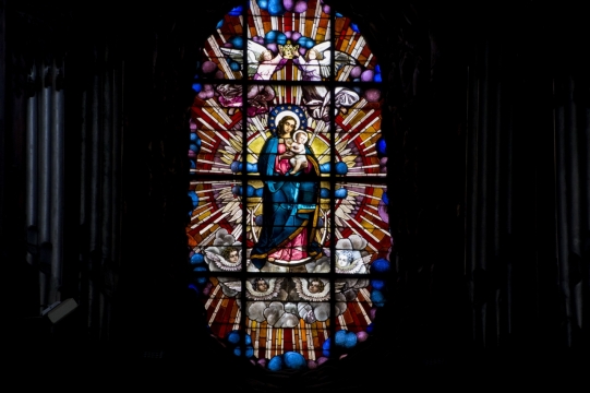 黑暗中画着圣母玛利亚像的教堂玻璃