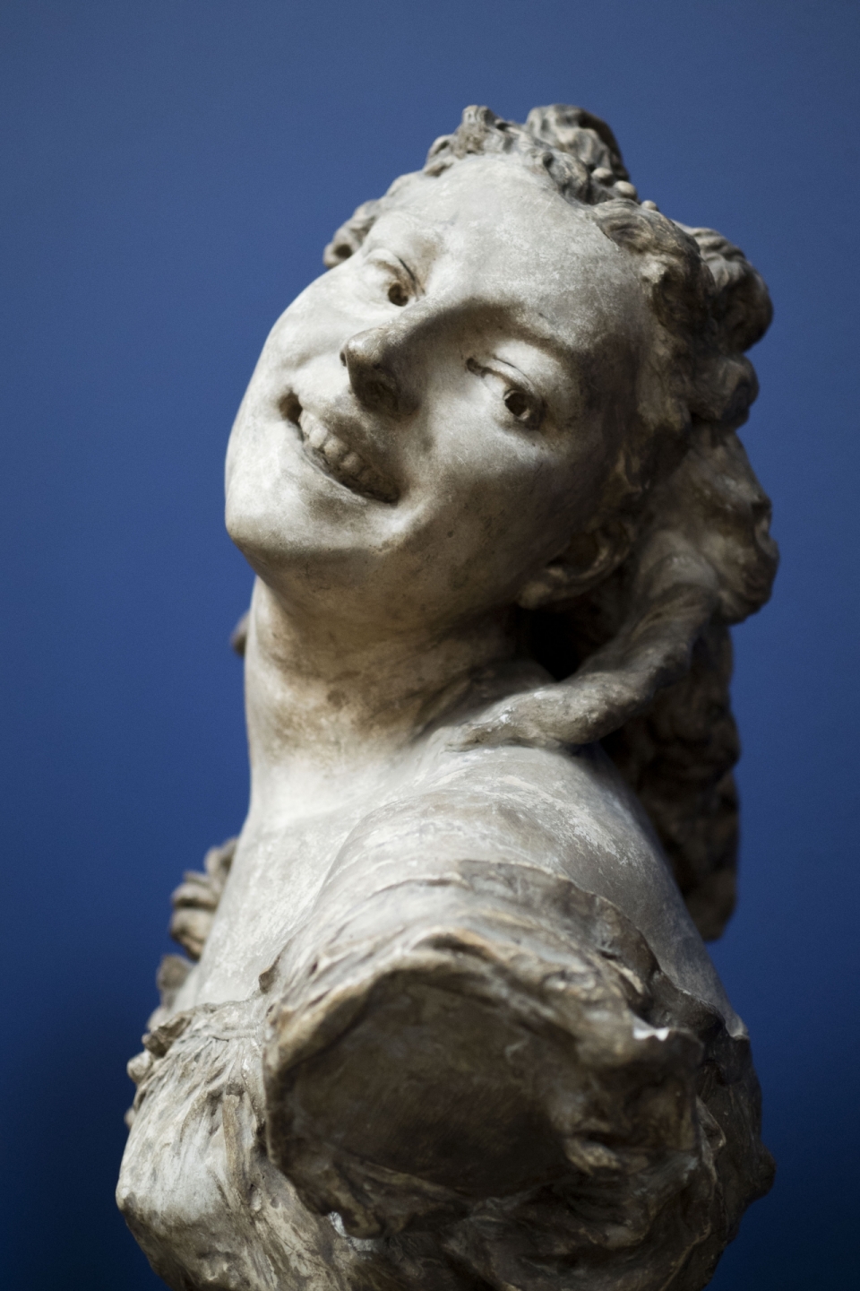 蓝色背景古老白色石质女性塑像