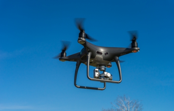 晴朗蓝色天空中飞翔黑色新型无人机