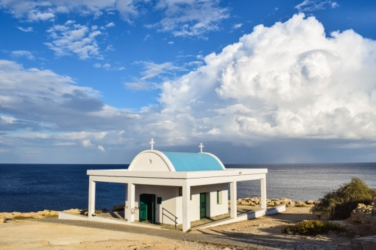 湛蓝天空中壮丽的云层与大海边休息屋