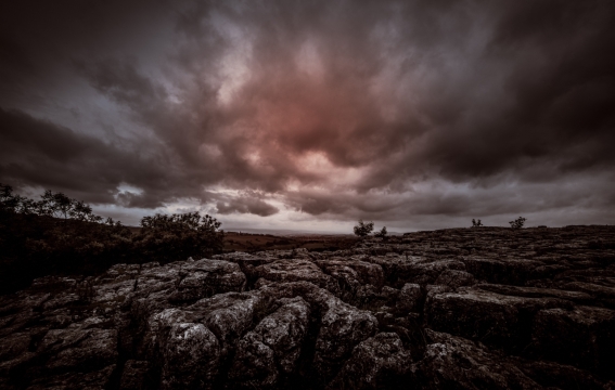 阴云遮盖住的夕阳下平原岩石