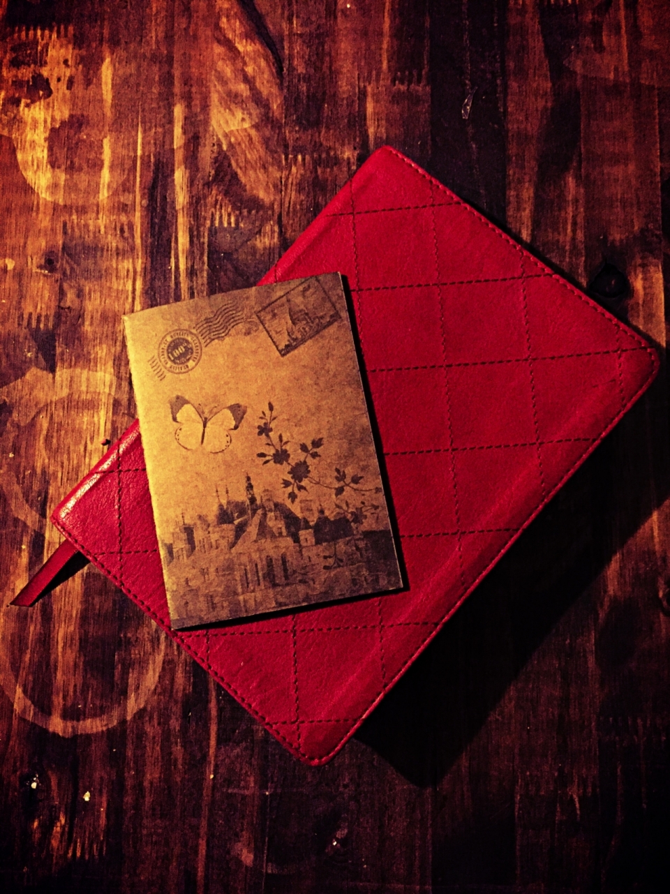 复古风木质桌子上笔记本和红色手包